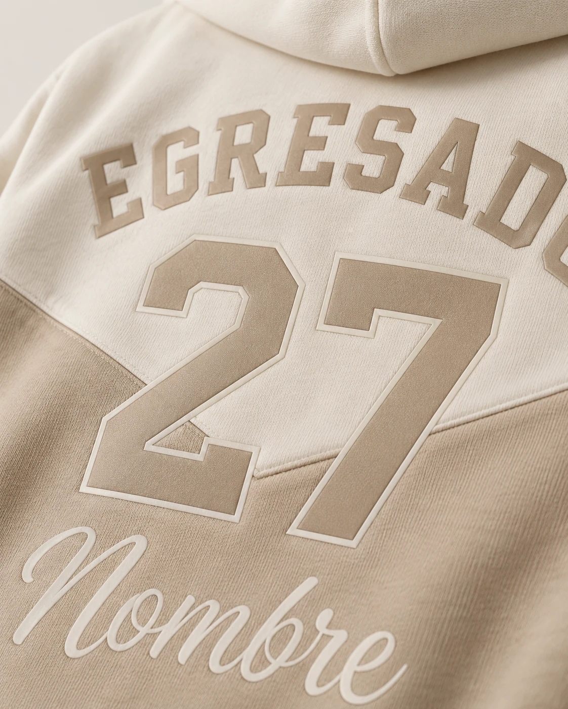 Campera crema y beige de frisa premium con Egresado 27 y Nombre aplicados en DTF. Vista de detalle.
