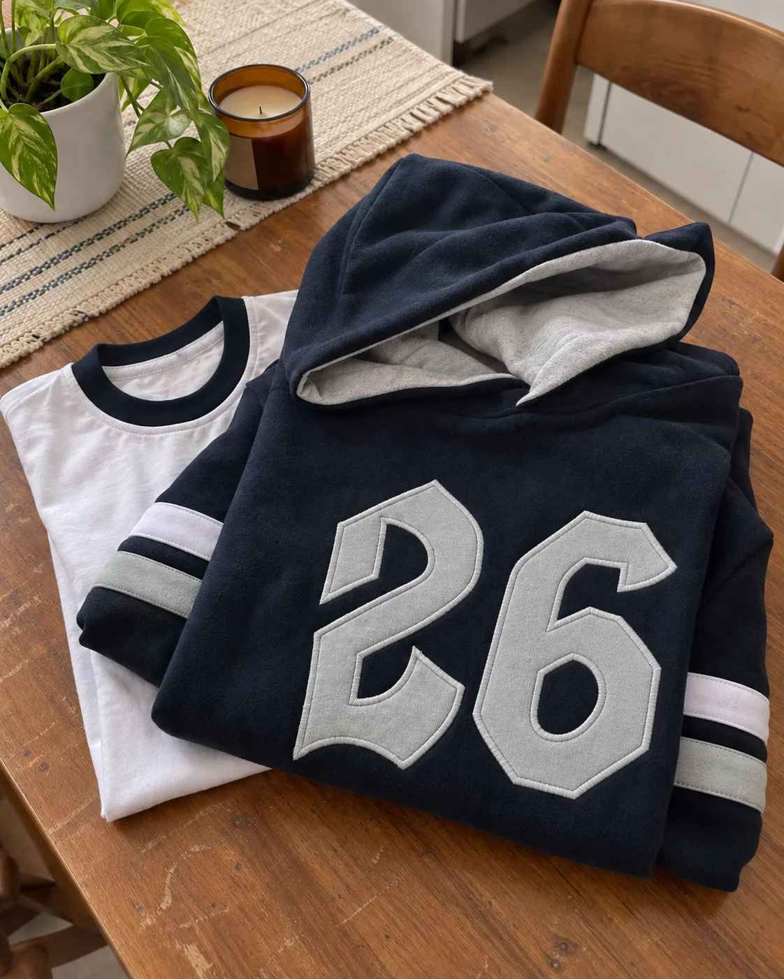 Imagen generada con IA: buzo azul marino con el número 26 y remera sobre una mesa gastada.